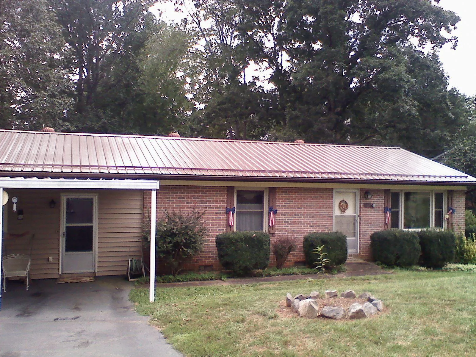 Bronze metal roof and carport on a brick ranch home — Roof Repair work by our crew in Smithfield